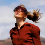 Femme en robe rouge avec visière sous le soleil.