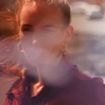 Femme floue avec lumière douce et reflets.