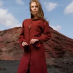 Femme en robe rouge sur fond volcanique